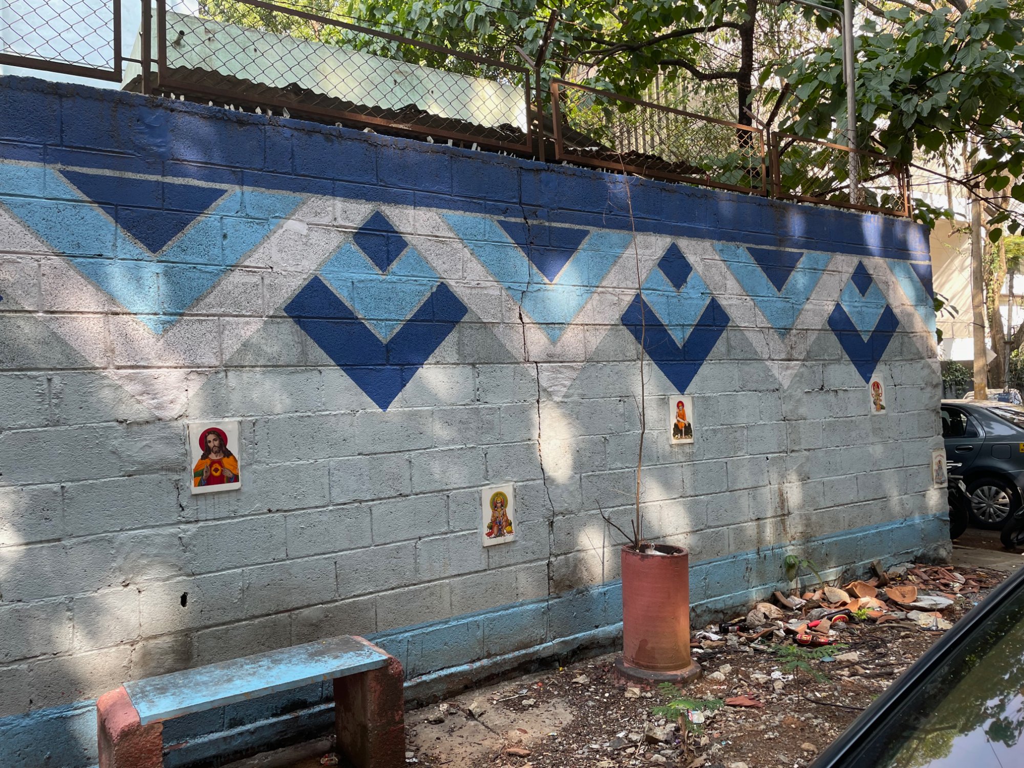 Religious figures affixed to a Bangalore wall to deter public urination — a street-level solution to a city-scale problem